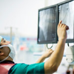 Photograph of surgeon monitoring screen for stage 2 throat cancer treatment