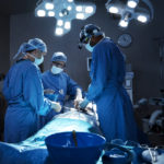 Photograph of multiple onco-surgeons performing surgery for throat cancer treatment