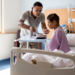 Photograph of patient and caregiver, as throat cancer patient recovers